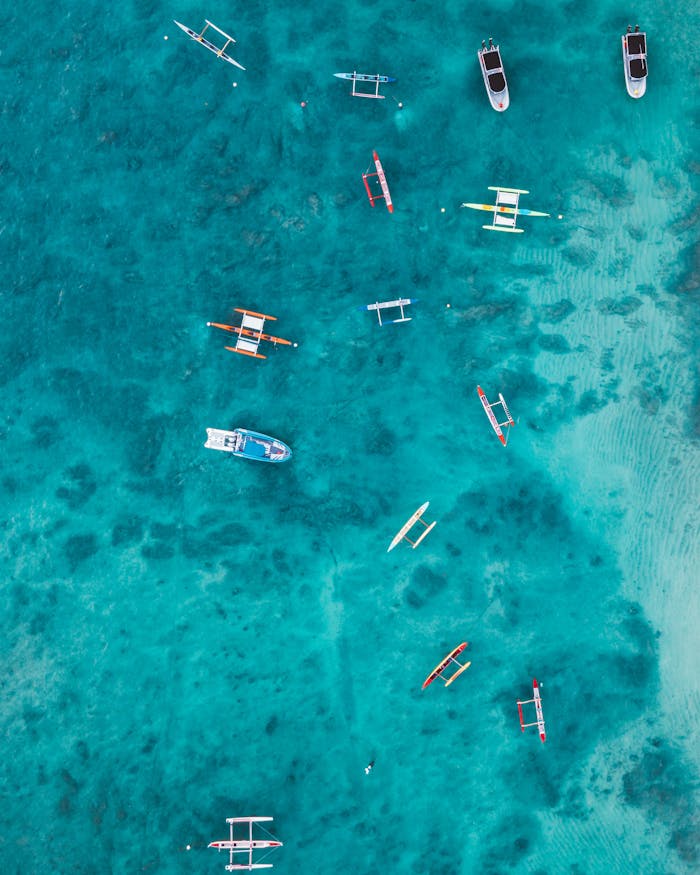 Aerial photo of boats floating in turquoise waters off Waikiki, Hawaii.